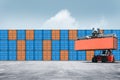 Stack of colorful containers box cargo in port shipping yard with Container handler in loading with floor ground and blue sky Royalty Free Stock Photo