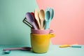 stack of colorful cooking utensils on a pastel background