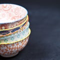 Stack of colorful empty ceramic bowls closeup on black board background Royalty Free Stock Photo