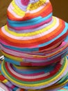 A stack of colorful summer hats at a street market stall in Brescia