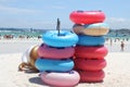 Stack of colorful inflatable swimming rings on the beach in sunny day.