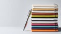 Stack of Colorful Journals With a Pen on a Clean White Surface for Creative Writing and Note-Taking Activities Royalty Free Stock Photo