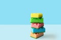 Stack of colorful kitchen cleaning sponges with soap bubbles on blue background Royalty Free Stock Photo