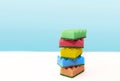 Stack of colorful kitchen cleaning sponges with soap bubbles on blue background Royalty Free Stock Photo