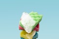 Stack of colorful kitchen cleaning sponges with soap bubbles on blue background Royalty Free Stock Photo