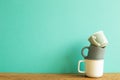 Stack of colorful mug cups on wooden table Royalty Free Stock Photo
