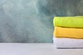 Stack of colorful natural cotton towels. Bathroom interior with decorative stucco background