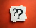 Paper notes with question marks on Coral background, flat lay. Space for text Royalty Free Stock Photo