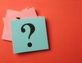 Paper notes with question marks on Coral background, flat lay. Space for text Royalty Free Stock Photo