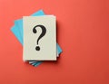 Paper notes with question marks on Coral background, flat lay. Space for text Royalty Free Stock Photo