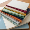 A stack of colorful notebooks is arranged on a wooden surface. Each notebook cover Royalty Free Stock Photo