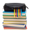 A stack of colorful notebooks and pencils with a black pencil case on top Royalty Free Stock Photo