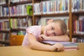 Stack of colorful notebooks resting on wooden table in library reading area, with tall bookshelf Royalty Free Stock Photo