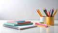 Stack of colorful notebooks and supplies on a clean white table Royalty Free Stock Photo