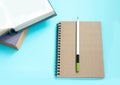 Stack of colorful old hardback books with brown notebook and pencil. Many Books Piles. Hardback books on blue table Royalty Free Stock Photo