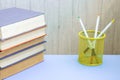 Stack of colorful old hardback books glass with pencils. Hardback books