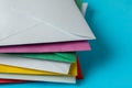 Stack of colorful paper envelopes on light blue background, closeup Royalty Free Stock Photo