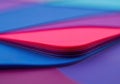 A stack of colorful paper sheets with a red top sheet on a blue and purple background Royalty Free Stock Photo
