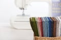 Stack of colorful quilting fabrics in basket on the background of sewing machine