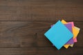 Stack of colorful stickers on wooden table, top view. Space for text Royalty Free Stock Photo