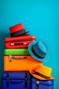 A stack of colorful suitcases and hats on a blue background Royalty Free Stock Photo
