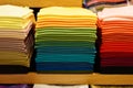 Stack of colorful t-shirts. Layers of colorful fabric. Stack of colorful folded clothes, multicolored background