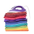 Stack of colorful t-shirts and the top of the iron, isolated on white background. File contains a path to isolation. Royalty Free Stock Photo