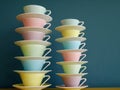 Stack of colorful vintage tea and coffee cups against petrol background. Royalty Free Stock Photo