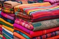 a stack of colorful woven rugs at a market stall