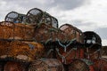 Orange lobster pots stacked on Scottish quay under cloudy sky Royalty Free Stock Photo