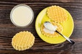 Stack of cookies, condensed milk in spoon on cookie in saucer, bowl with condensed milk on wooden table. Top view Royalty Free Stock Photo