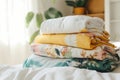 Stack of cotton colorful clothes on a bed indoors. Stacked apparel. Folded clean clothing. Household