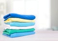 Stack of cotton colorful folded clothes on table empty space