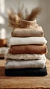 Stack of cozy knit sweaters on wooden table in warm neutral tones Royalty Free Stock Photo