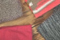 Stack of cozy knitted sweaters. A pile of warm sweaters on a wooden table on rustic background. Autumn and winter clothes. Copy