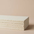 A stack of cream-colored papers with deckled edges is neatly arranged on a light tan Royalty Free Stock Photo