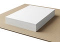A stack of crisp white paper rests on a brown cardboard surface ready for creative use Royalty Free Stock Photo