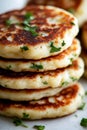 Stack of crispy golden potato pancakes with fresh herbs, close-up on white background Royalty Free Stock Photo
