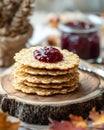 A stack of crispy oat cakes topped with a dollop of jam on a wooden platter Royalty Free Stock Photo
