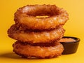 A stack of crispy onion rings with dipping sauce. Royalty Free Stock Photo