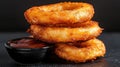 A stack of crispy onion rings with dipping sauce. Royalty Free Stock Photo