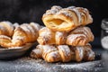 stack of croissants, layered with rich and flaky dough, and topped with a dusting of powdered sugar