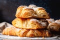 stack of croissants, layered with rich and flaky dough, and topped with a dusting of powdered sugar