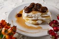 A stack of crumpets and pancakes with sour cream and strawberry sweet jam with berries on top of the dish Royalty Free Stock Photo