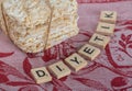 Stack of crusty crispbread and wooden letters on red cloth