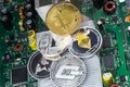 Stack of cryptocurrencies: bitcoin, ethereum, litecoin, dash, and ripple coin together. The background is a computer circuit Board