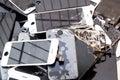 Stack of damaged smart phone body and cracked LCD screen