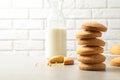 Stack of Danish butter cookies and milk on table against brick wall. Royalty Free Stock Photo