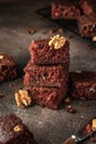 Stack of delicious brownie pieces with hazelnuts on dark background Royalty Free Stock Photo