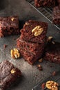 Stack of delicious brownie pieces with hazelnuts on dark background Royalty Free Stock Photo